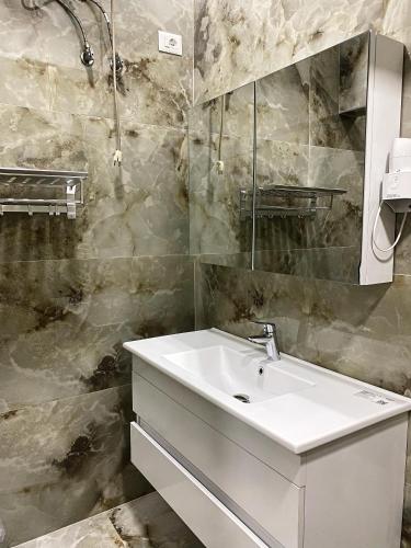a bathroom with a white sink and a mirror at stefanias apartment in Tirana