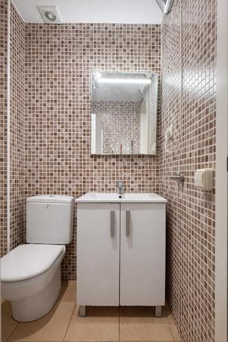 a bathroom with a toilet and a sink and a mirror at Casa de Mar in Lloret de Mar