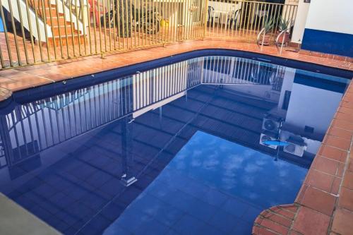 a swimming pool with a fence and blue water at Hotel Pisci Stars Sra in Saravena