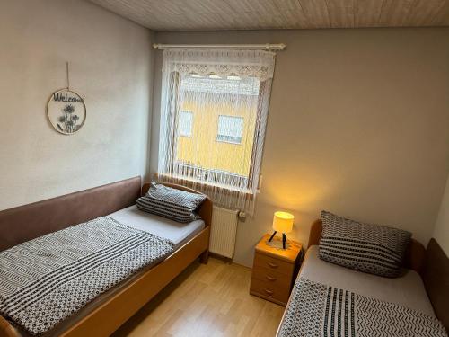 a bedroom with two twin beds and a window at Ferienwohnung Pellenz in Bremm