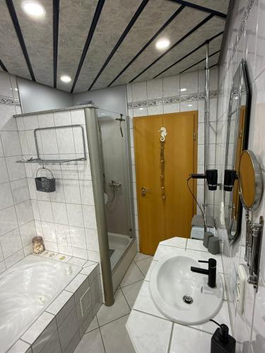 a bathroom with a tub and a sink and a shower at Ferienwohnung Pellenz in Bremm