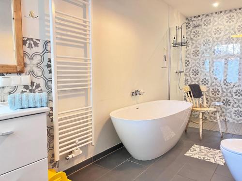 a white bathroom with a tub and a shower at Wendlandhof Lüggau in Dannenberg