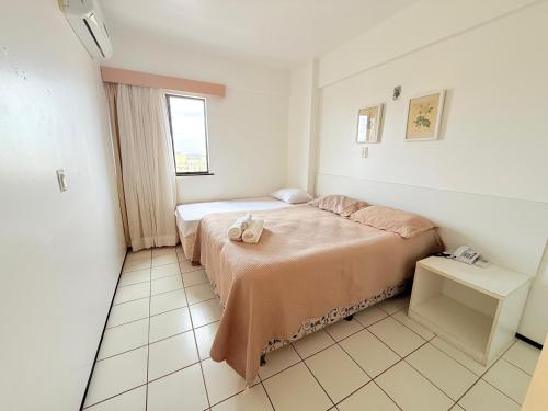 a small bedroom with a bed and a window at Biarritz praia in São Luís
