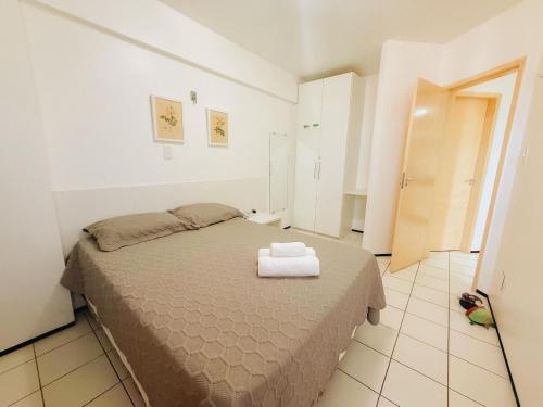 a bedroom with a bed with two towels on it at Biarritz praia in São Luís