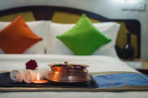 a tray with a candle and towels on a bed at Dahlia Boutique Hotel in Pokhara