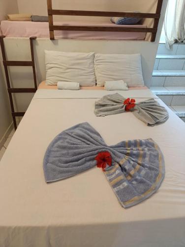 two pairs of mens clothes on a bed at Hospedagem Terral Beach Canoa Quebrada in Aracati