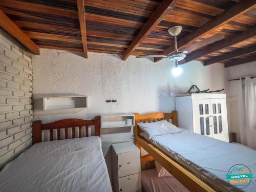 two twin beds in a room with wooden ceilings at hostel Bike Point Caraguatatuba in Caraguatatuba