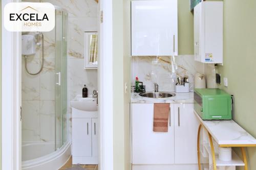 a white bathroom with a shower and a sink at Modern Airport Annexe - Free Parking - Sleeps 4 - Near Luton Airport in Luton
