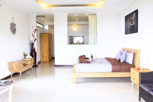 a bedroom with a bed with a teddy bear laying on it at The Kayuan in Kintamani
