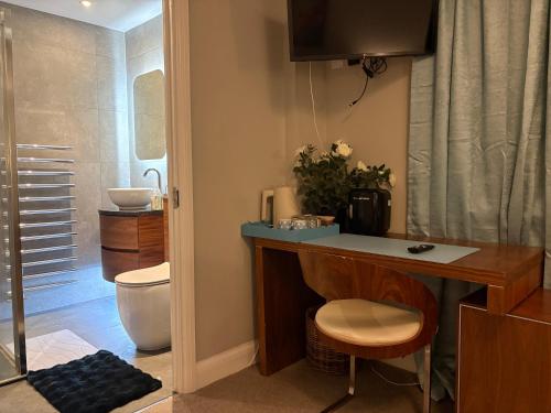 a bathroom with a sink and a toilet and a desk at Were House Warminster in Warminster