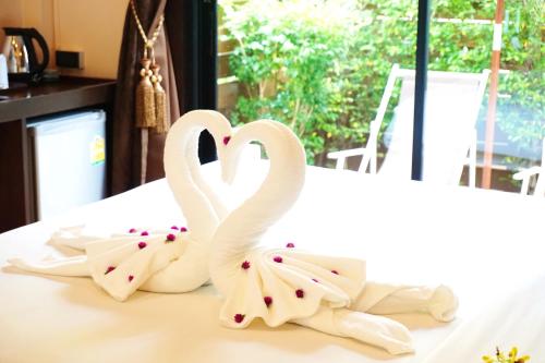 two white swans making a heart on a bed at Lamai Inn 99 Bungalows in Lamai