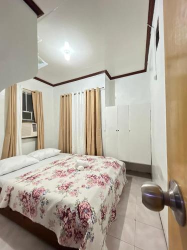 a bedroom with a bed with a floral bedspread at Triple K Transient House in Butuan