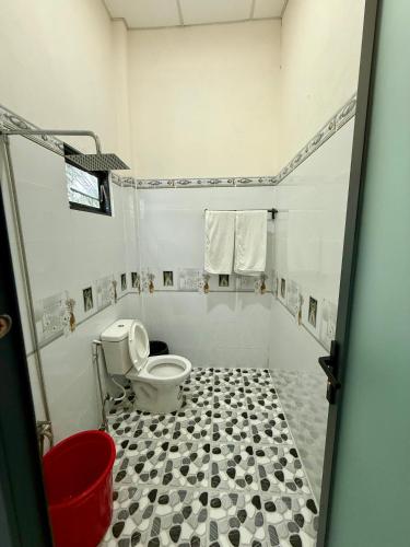 a bathroom with a toilet and a black and white tiled floor at Thùy Vinh Homestay in Phú Quốc