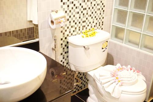 a bathroom with a white toilet and a sink at Lamai Inn 99 Bungalows in Lamai