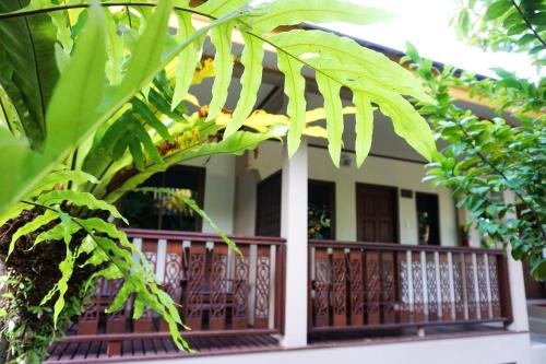 a house with a balcony with chairs and trees at Lamai Inn 99 Bungalows in Lamai
