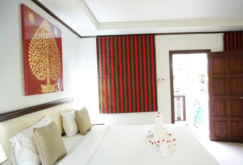 a bedroom with a white bed and a red curtain at Lamai Inn 99 Bungalows in Lamai