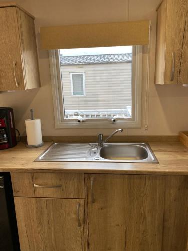a kitchen counter with a sink and a window at 230 Unity Holiday Resort 6 Birth cosy and secure property next to all shops and entertainment passes optional in Brean