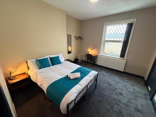 a bedroom with a large bed with blue pillows at The Victoria Bar & Hotel in Wakefield