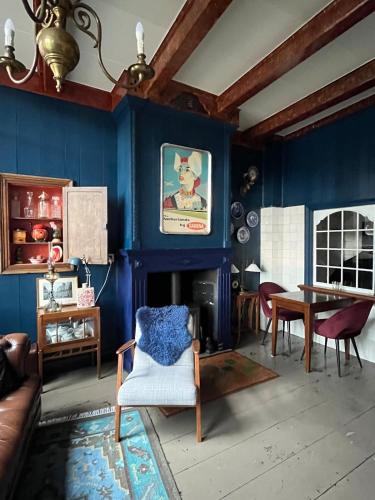 a living room with blue walls and a chair and a table at De Kleine Prins Enkhuizen in Enkhuizen