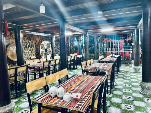 a dining room with tables and chairs and a mural at Homestay Mường Lay in Bản Pong