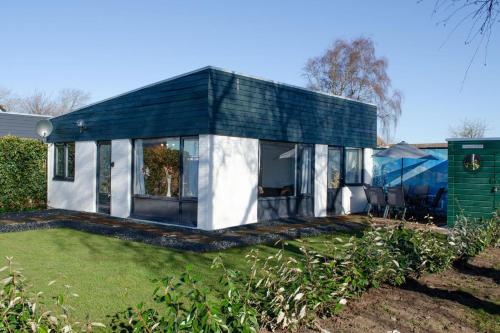 a black and white house with a yard at Golden house - Bungalow near the beach in Noordwijkerhout