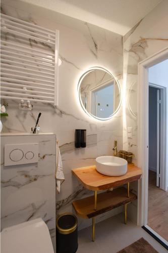 a white bathroom with a sink and a mirror at Golden house - Bungalow near the beach in Noordwijkerhout
