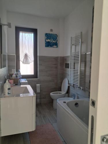 a bathroom with a tub and a toilet and a sink at Il Nido di Chiara 2 in Formia