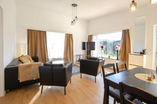 a living room with a bed and a dining room at Golden house - Bungalow near the beach in Noordwijkerhout