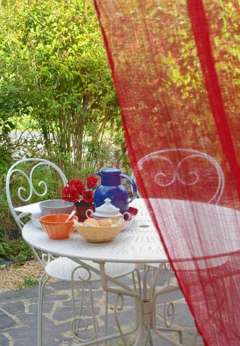 a table with a tea pot and flowers on it at Domaine de la Cour in Sainte-Gemme-dʼAndigné