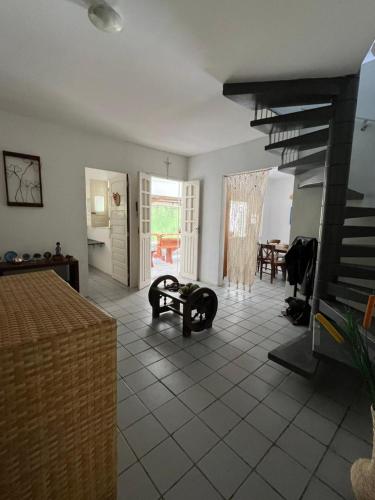 a living room with a staircase and a dining room at Canto da Ita - Próxima a praia com piscina e churrasqueira in Itamaracá