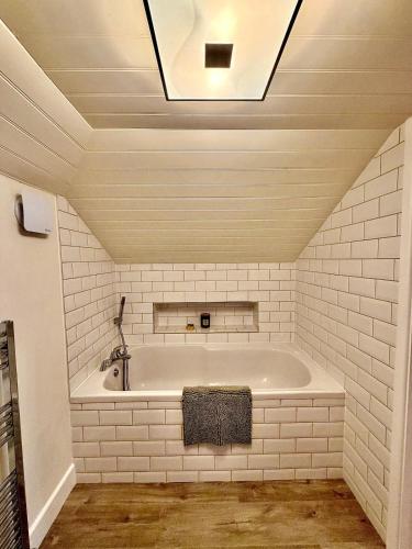 a bath tub in a room with a ceiling at Cosy stay within South Downs! in Southampton