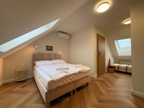 a bedroom with a large bed with a skylight at Kwietny Stoczek 70 in Białowieża