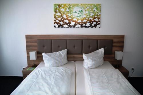a bedroom with two beds and a painting on the wall at Gästehaus Pauline in Berlin