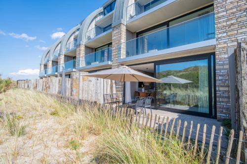 an umbrella sitting outside of a building at Residence Westduin in Sint Maartensvlotbrug