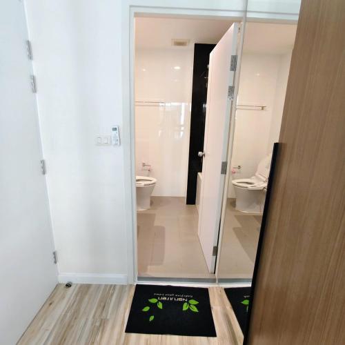 a bathroom with a shower and a toilet and a rug at Plus Sriracha Condo NEW Building in Si Racha