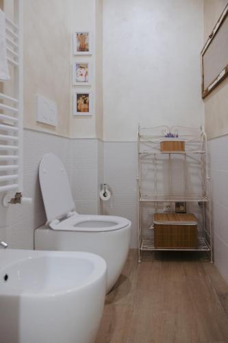 a white bathroom with a toilet and a sink at La Loggia Del Popolo in Ascoli Piceno