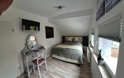 a bedroom with a bed and a mirror and a dresser at Casa-Mandelartz in Rees