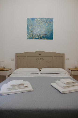 a bed with two towels on top of it at La Loggia Del Popolo in Ascoli Piceno