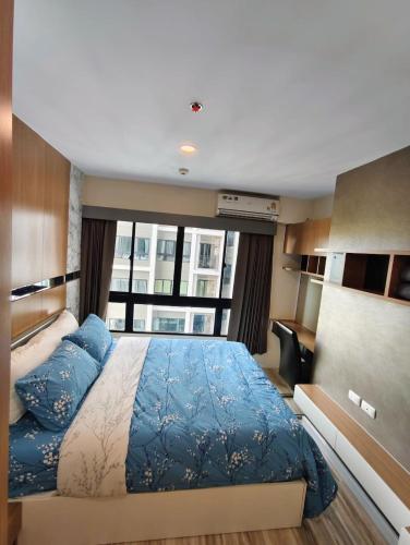 a bedroom with a large bed and a large window at Plus Sriracha Condo NEW Building in Si Racha