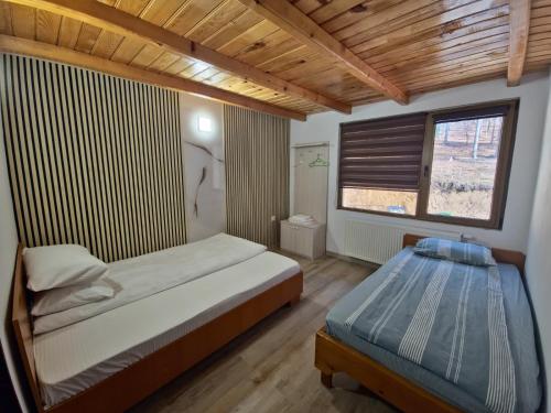 a bedroom with a bed and a window at Cabana Valea Bradului in Nucşoara