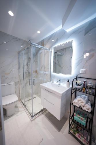 a bathroom with a shower and a sink and a toilet at Pearl Port House in Ágios Rókkos