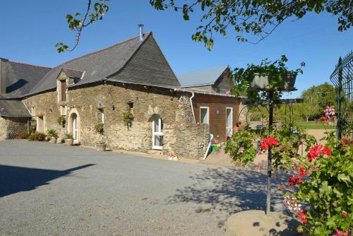 a large stone building with a roof at Domaine de la Cour in Sainte-Gemme-dʼAndigné