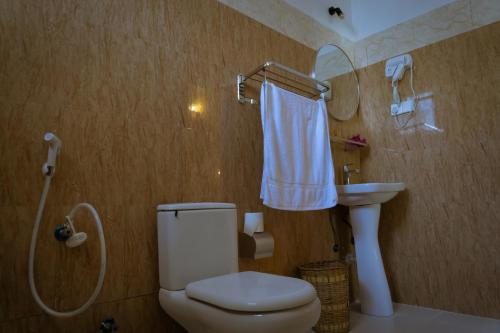 a bathroom with a toilet and a sink and a mirror at Kendwa Sky Hotel in Kendwa