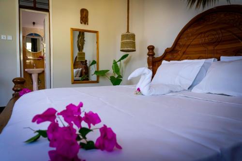 a bedroom with a bed with purple flowers on it at Kendwa Sky Hotel in Kendwa