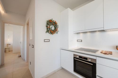 una cucina con mobili bianchi e una ghirlanda sulla parete di Avaton a Vátos