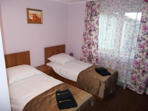 a room with two twin beds and a window at Willa Poniatowskiego in Grodzisk Mazowiecki