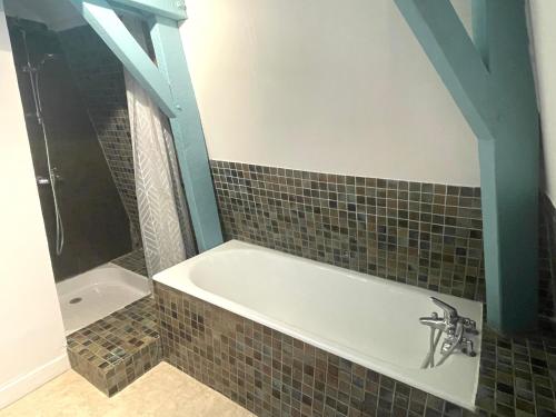 a bathroom with a bath tub and a sink at Le Petit Manoir avec Piscine Privée in Le Bugue