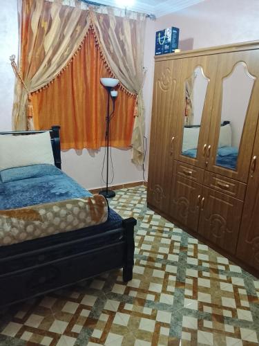 a bedroom with a bed and a dresser and a mirror at Sidi boulfdyl in Tiznit