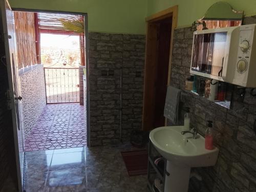 a bathroom with a sink and a door to a yard at Sidi boulfdyl in Tiznit