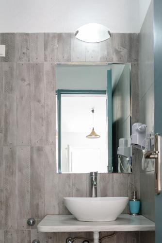 a bathroom with a sink and a mirror at Iris Boutique Hotel in Kamari
